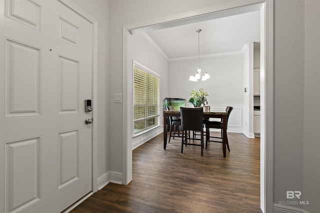 dining room with crown molding, a chandelier, dark wood-style flooring, and baseboards