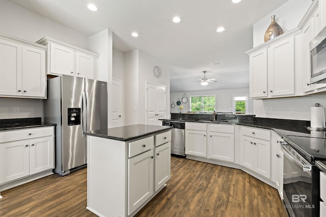 kitchen with appliances with stainless steel finishes, a sink, dark wood-style floors, white cabinets, and recessed lighting
