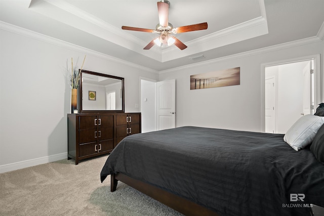 bedroom featuring a raised ceiling, light colored carpet, ornamental molding, a ceiling fan, and baseboards