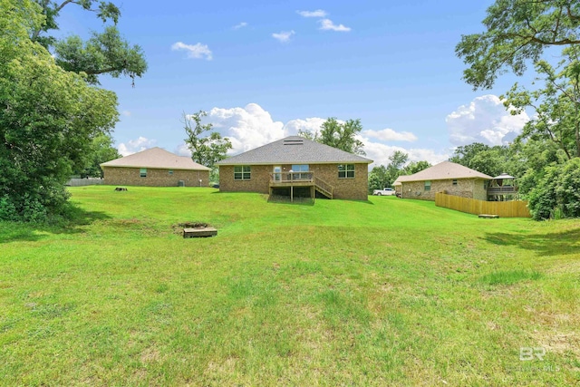 view of yard featuring a deck, a fire pit, and stairs