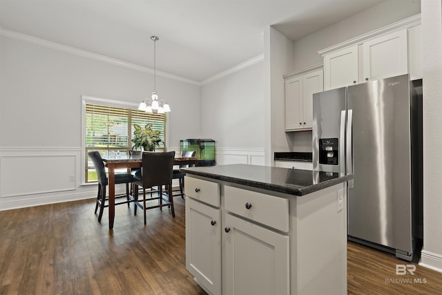 kitchen featuring stainless steel fridge, ornamental molding, white cabinets, a center island, and dark wood finished floors