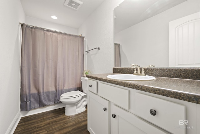 full bath featuring toilet, wood finished floors, vanity, and recessed lighting