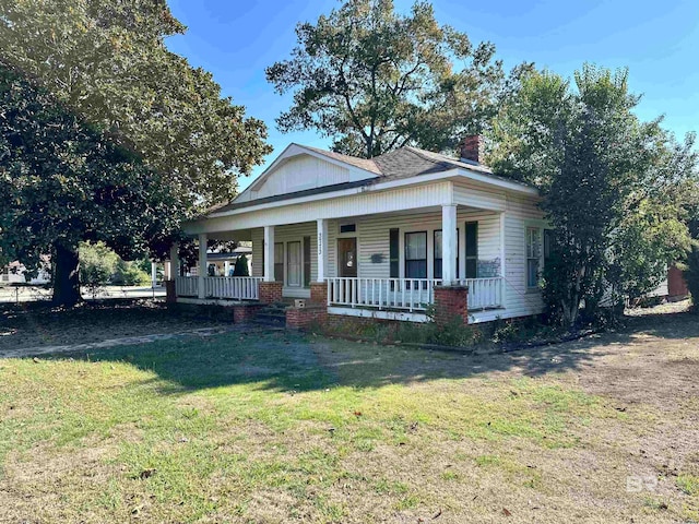 view of front facade featuring covered porch and a front lawn