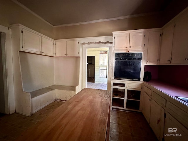 kitchen featuring oven, crown molding, and white cabinets