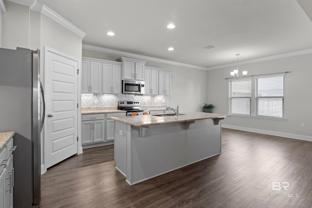 kitchen featuring white cabinetry, light stone counters, dark hardwood / wood-style flooring, a center island with sink, and appliances with stainless steel finishes