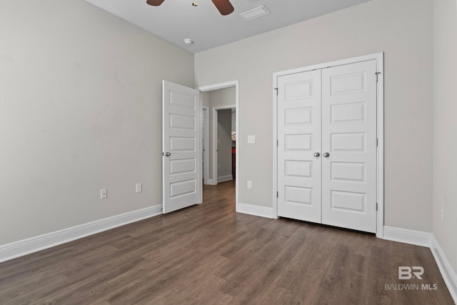 unfurnished bedroom featuring ceiling fan, a closet, and dark wood-type flooring