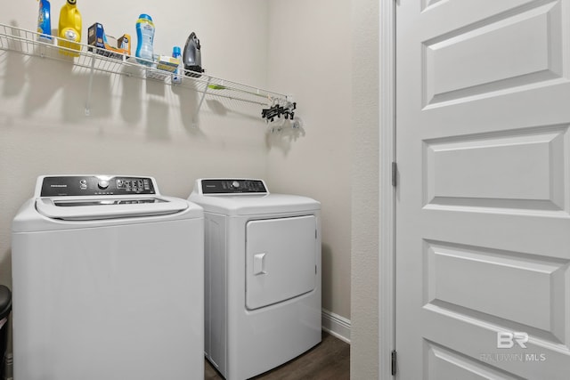 clothes washing area with washer and dryer and dark wood-type flooring