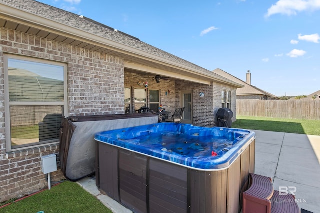 view of patio featuring a grill, ceiling fan, and a hot tub