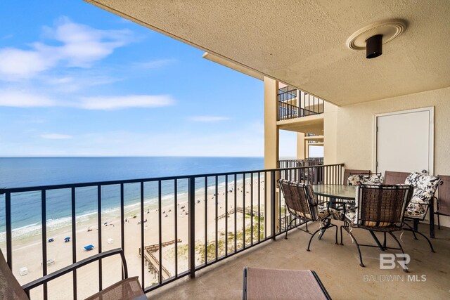 balcony featuring a beach view and a water view