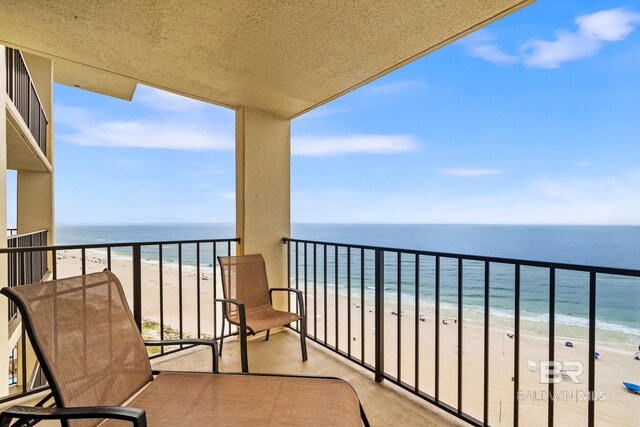 balcony with a water view and a beach view