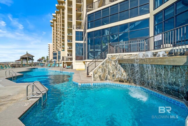 view of pool with pool water feature and a patio