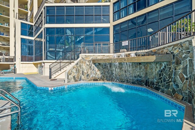 view of swimming pool featuring pool water feature and a patio area