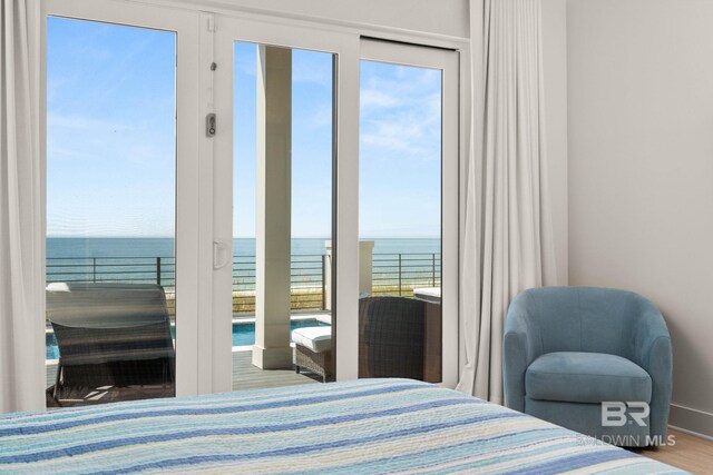 bedroom with wood-type flooring and a water view