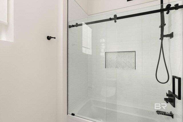 bathroom with shower / bath combination with glass door