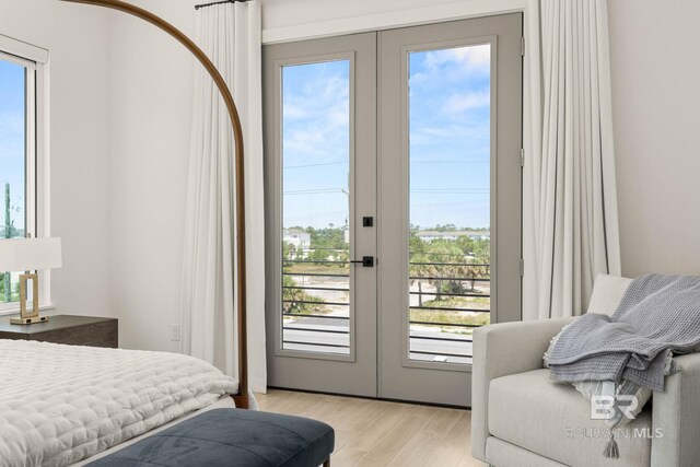 bedroom with french doors and light hardwood / wood-style floors