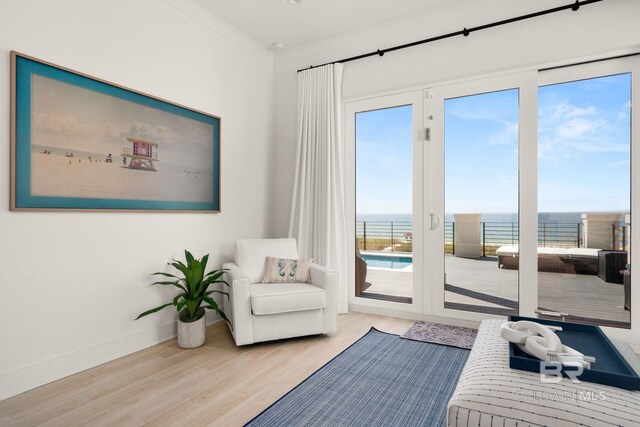 sitting room featuring light hardwood / wood-style flooring and a water view