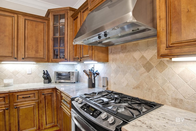 17541 Council Oaks Ln, Bon Secour, AL 36511 - kitchen with wall chimney exhaust hood, stainless steel gas stove, and brown cabinets