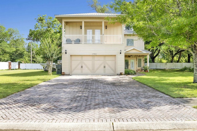 17541 Council Oaks Ln, Bon Secour, AL 36511 - view of front property with french doors, decorative driveway, a garage, and a balcony