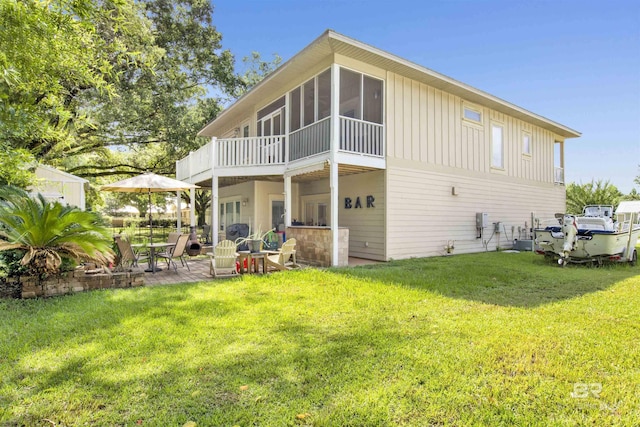 17541 Council Oaks Ln, Bon Secour, AL 36511 - back of property with board and batten siding, a lawn, a patio area, and a sunroom