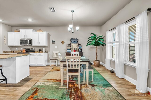 dining area with light wood-style flooring, baseboards, recessed lighting, and a chandelier