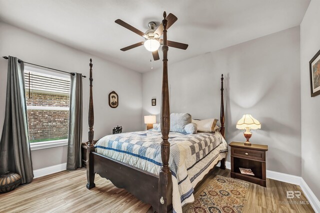 bedroom featuring baseboards, light wood finished floors, and ceiling fan
