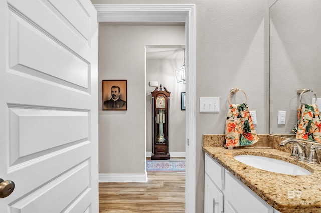 bathroom featuring wood finished floors, vanity, and baseboards