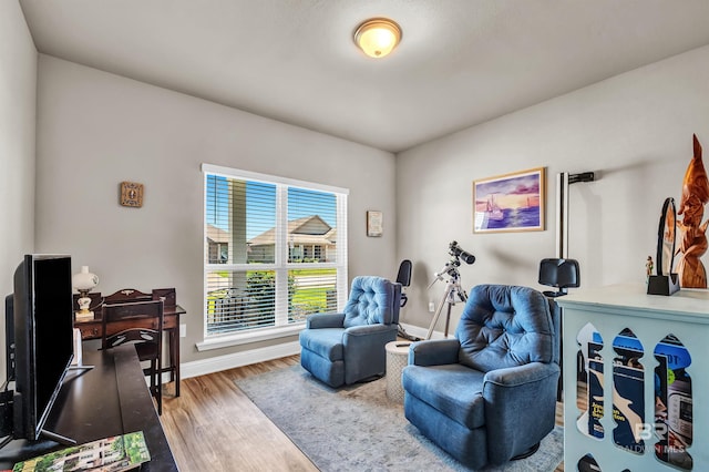 sitting room featuring wood finished floors, baseboards, and an office area
