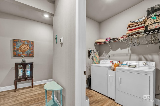 washroom featuring independent washer and dryer, light wood finished floors, and baseboards