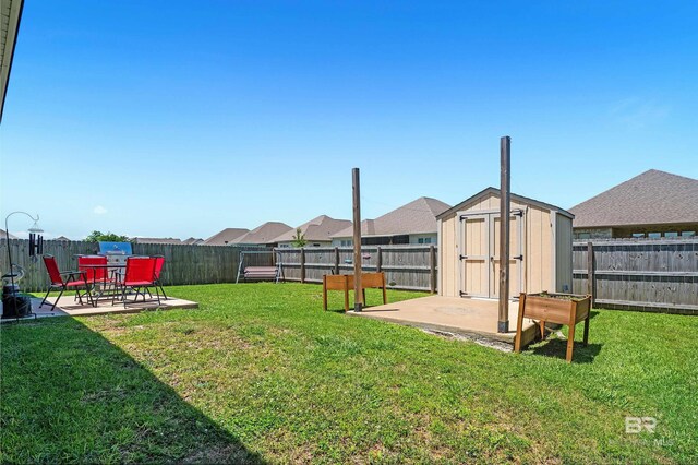 view of yard with a patio, a shed, and an outbuilding