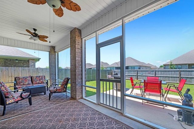 sunroom featuring an outdoor hangout area, ceiling fan, and a residential view