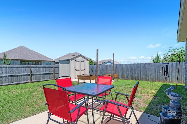 view of patio with a storage unit, outdoor dining space, and an outbuilding