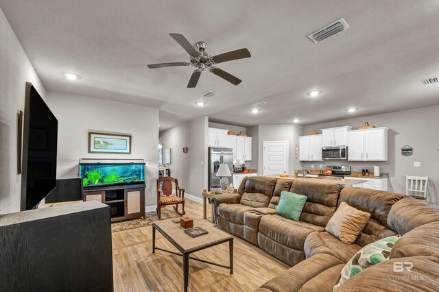living area featuring light wood-type flooring, ceiling fan, recessed lighting, and baseboards