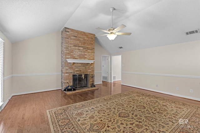 unfurnished living room with visible vents, wood finished floors, a ceiling fan, and vaulted ceiling