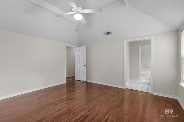 unfurnished room with visible vents, a ceiling fan, wood finished floors, baseboards, and lofted ceiling