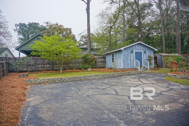 exterior space with aphalt driveway and a fenced backyard