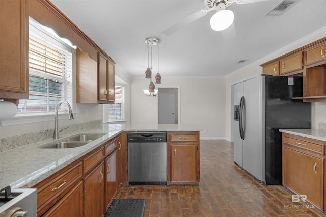 kitchen with a peninsula, a sink, appliances with stainless steel finishes, crown molding, and brown cabinets