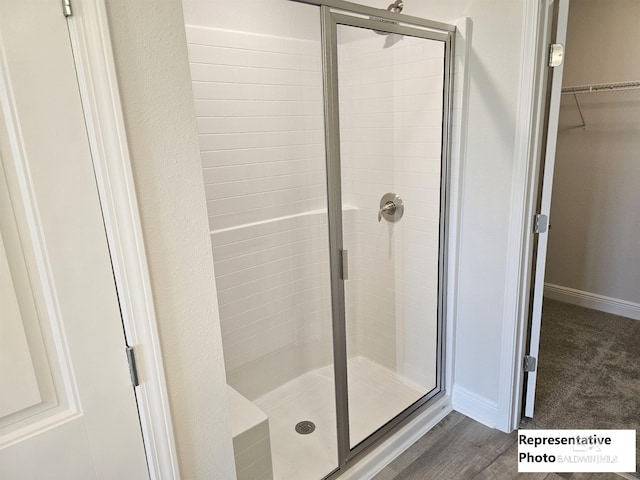 bathroom featuring hardwood / wood-style floors and a shower with door