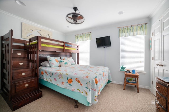 carpeted bedroom featuring crown molding, multiple windows, and a closet