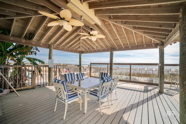 wooden terrace with ceiling fan, a water view, and a gazebo