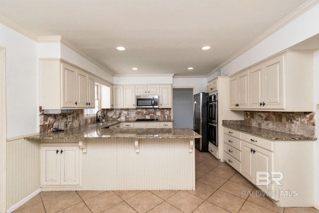 3755 N Claridge Rd, Mobile, AL 36608 - kitchen with stainless steel appliances, a peninsula, stone counters, a kitchen bar, and a sink