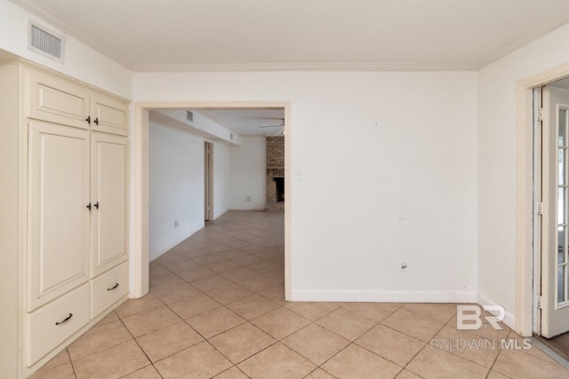 3755 N Claridge Rd, Mobile, AL 36608 - empty room with light tile patterned floors, crown molding, a fireplace, and baseboards