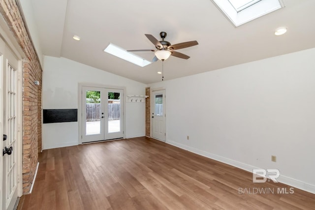 3755 N Claridge Rd, Mobile, AL 36608 - empty room featuring a skylight, french doors, ceiling fan, wood finished floors, and lofted ceiling