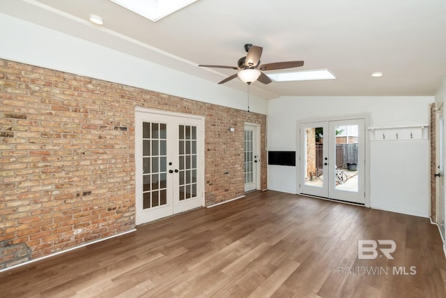 3755 N Claridge Rd, Mobile, AL 36608 - empty room with french doors, a skylight, brick wall, a ceiling fan, and lofted ceiling