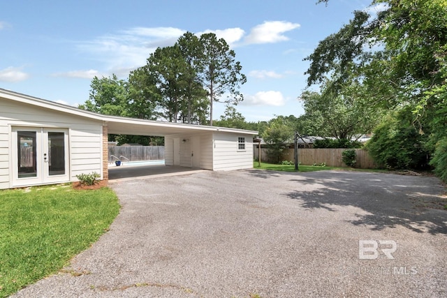 3755 N Claridge Rd, Mobile, AL 36608 - garage with driveway, french doors, and an attached carport