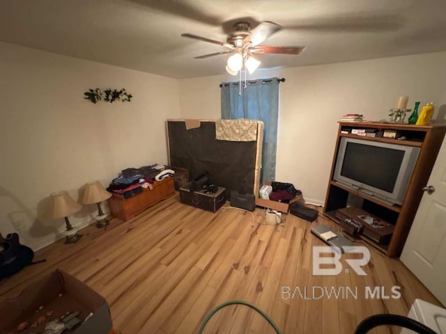 living area with ceiling fan, light wood-type flooring, and baseboards