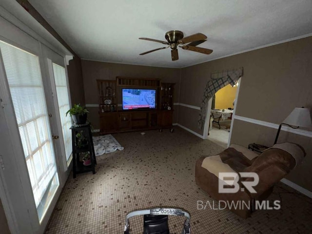 unfurnished living room with ornamental molding, a healthy amount of sunlight, light floors, and a ceiling fan