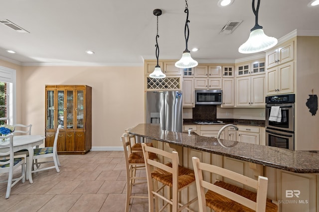 9791 Aspen Cir, Spanish Fort, AL 36527 - kitchen featuring stainless steel appliances, a breakfast bar, glass insert cabinets, crown molding, and cream cabinets
