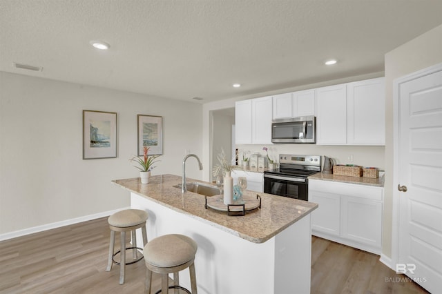 kitchen with white cabinetry, an island with sink, appliances with stainless steel finishes, and sink