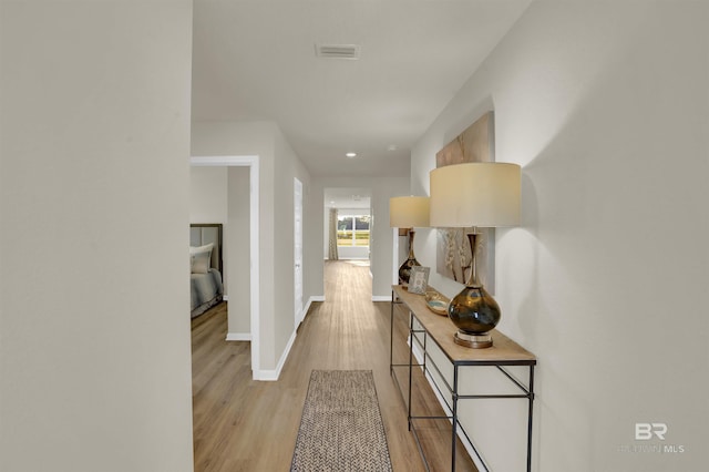 hallway with light hardwood / wood-style floors