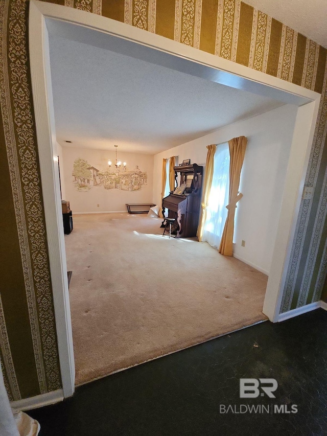 unfurnished living room with carpet floors and an inviting chandelier